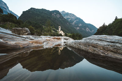 Scenic view of lake by mountains against clear sky