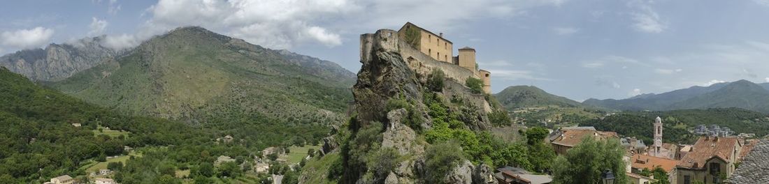 Panoramic view of buildings and mountains against sky