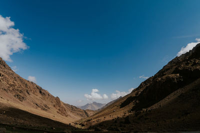 Scenic view of mountains against blue sky