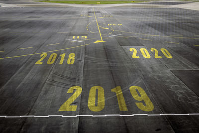 Closeup 2019 figures on the surface of the airport runway texture background.