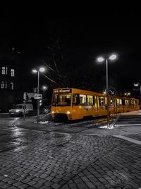 Cars on illuminated city against sky at night