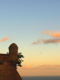 Low angle view of built structure at sunset