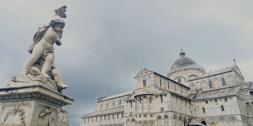 Low angle view of statue of historic building against sky