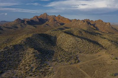 Scenic view of land and mountains against sky