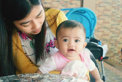 Portrait of cute baby girl with mother