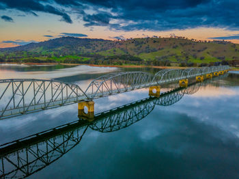 Bridge over lake against sky during sunset