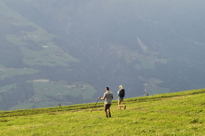 Rear view of men walking on mountain road