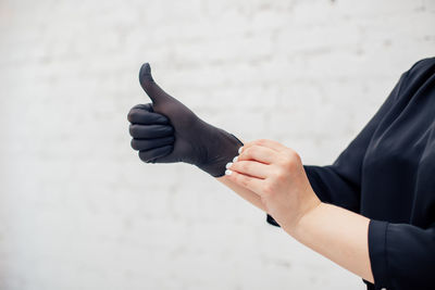 Midsection of man holding umbrella against wall