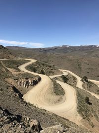Scenic view of mountain road against blue sky