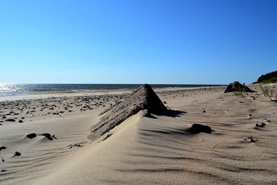 Scenic view of beach against clear blue sky