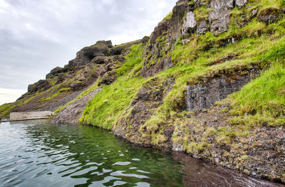 Scenic view of stream amidst rocks against sky