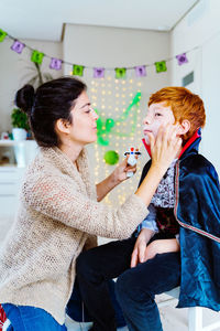 Side view of mother applying make up at home