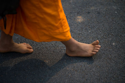 Low section of monk walking on street