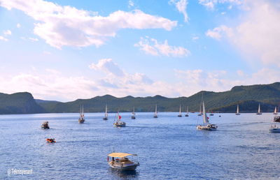 Sailboats in sea against sky