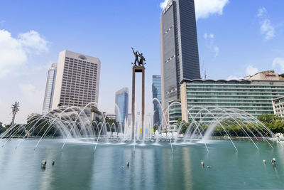 Fountain against buildings in city
