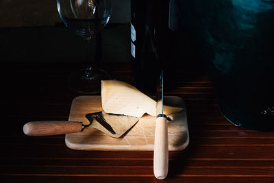 High angle view of cheese by wine bottle on table