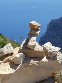 Close-up of rocks by sea against clear sky