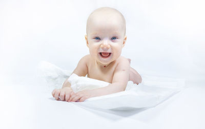 Portrait of cute baby boy lying on bed at home