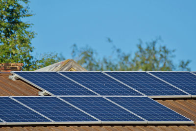 Low angle view of sun cell rooftop against blue sky
