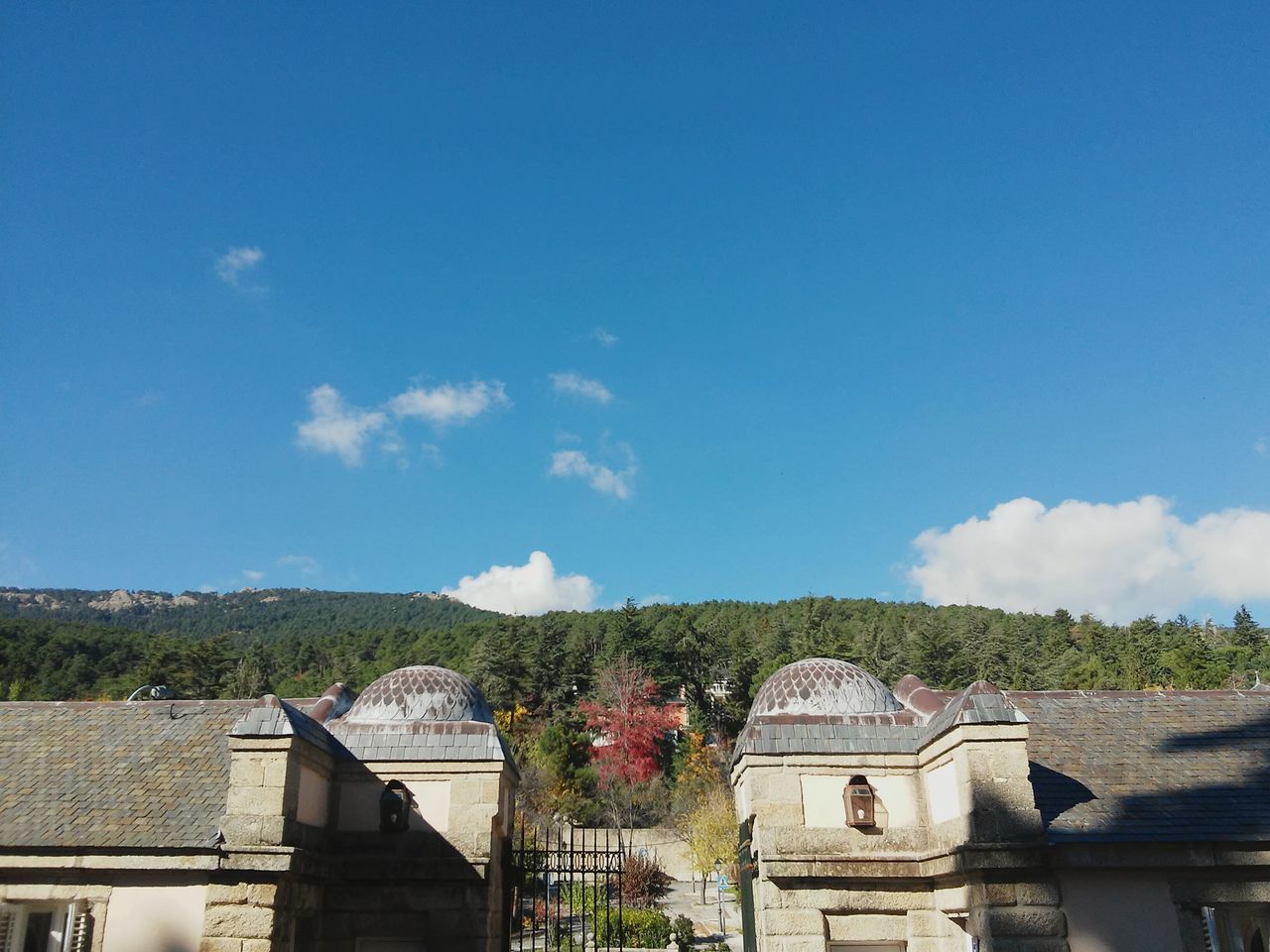 architecture, built structure, building exterior, sky, blue, low angle view, house, residential structure, cloud - sky, roof, cloud, residential building, day, tree, outdoors, no people, high section, sunlight, copy space, window