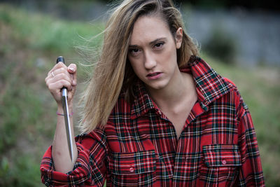 Portrait of young woman holding knife