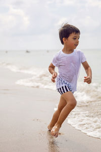 Side view of boy standing at beach
