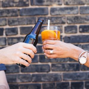 Cropped hand of man holding drink at table