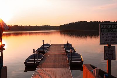 Reflection of text on lake against sky during sunset