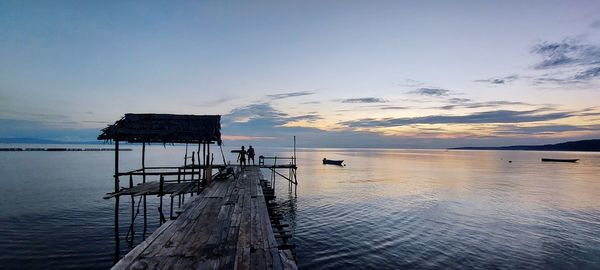 Pier on sea against sky during sunset