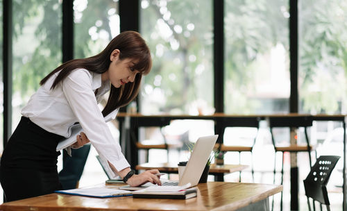 Woman using mobile phone at table