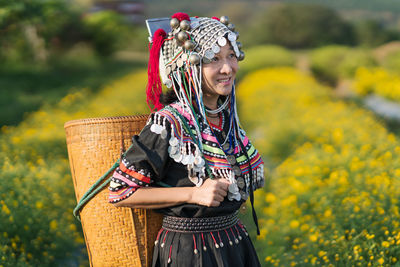 Full length of a smiling woman standing on field