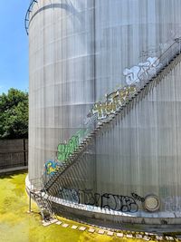 Metallic structure on bridge against buildings in city