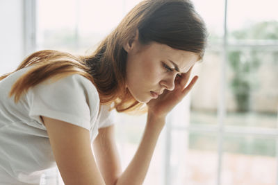 Portrait of young woman looking away at home