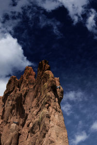 Low angle view of rock formations against cloudy sky