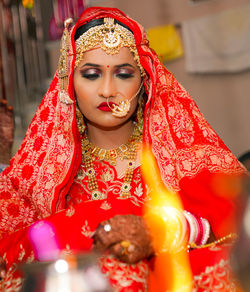 Close-up of bride wearing traditional clothing sitting in wedding ceremony