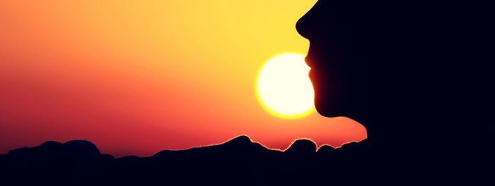 Silhouette person against orange sky during sunset
