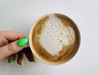 Cropped hand holding coffee on table