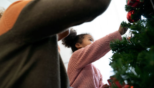 Rear view of people looking at christmas tree