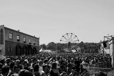 Crowd in front of amusement park against clear sky