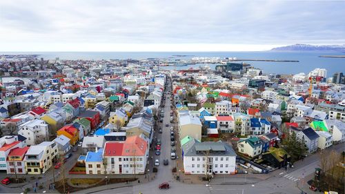 High angle view of townscape by sea against sky