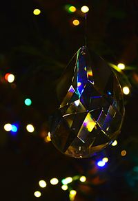 Close-up of illuminated lighting equipment hanging at night