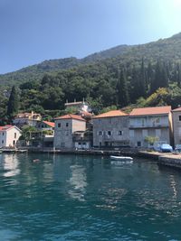 Scenic view of river by buildings against sky