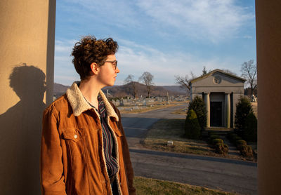 Side view of woman standing against buildings