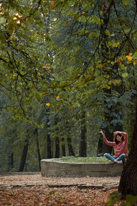 Rear view of woman standing on footpath in forest