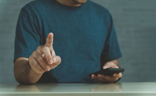 Midsection of man using mobile phone