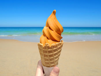 Thai tea soft serve ice-cream with beach in the summer background