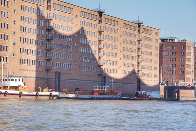 Boats in sea against buildings in city
