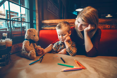 Boy sitting on table with toy