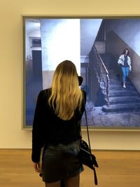 Rear view of woman standing in museum