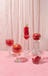 Still life arrangement of cristal glasses filled with red apples and pepper. creative copy space